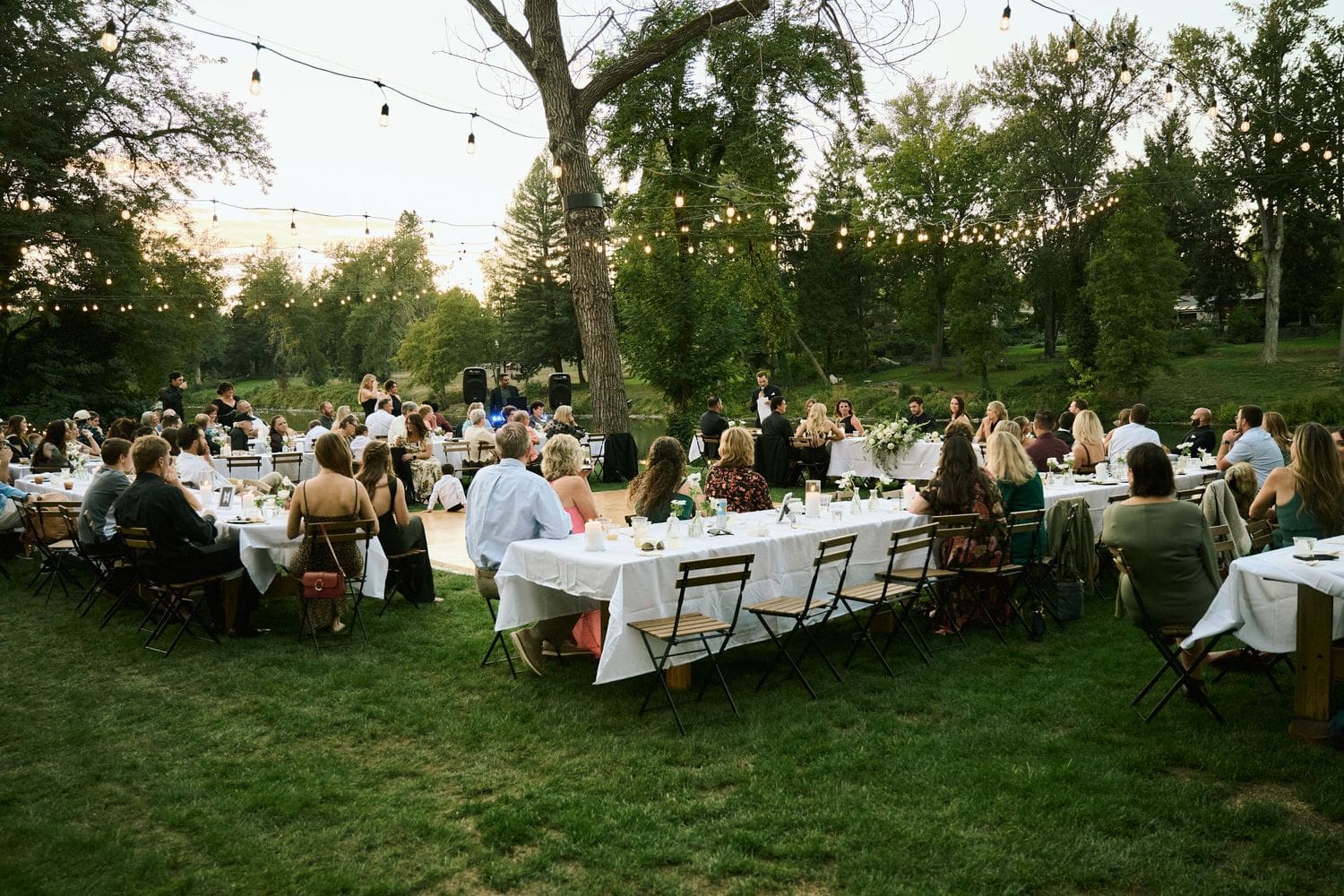 Wedding photographer documenting a group of guests near a stone patio and gardens at A River House