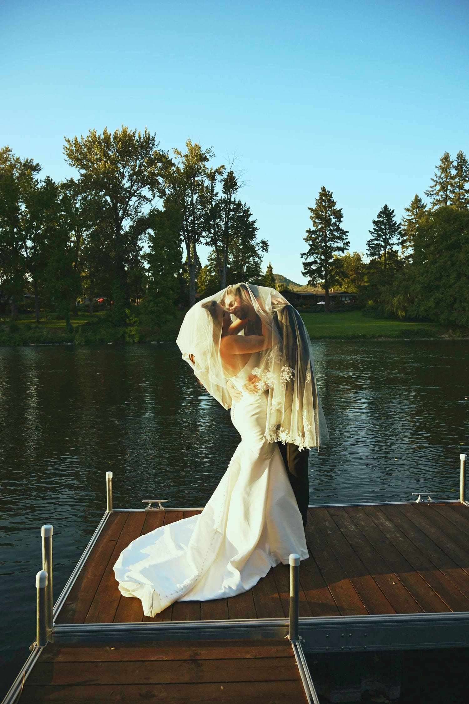 Aerial view of a lakeside wedding ceremony with guests and the couple walking the aisle at A River House