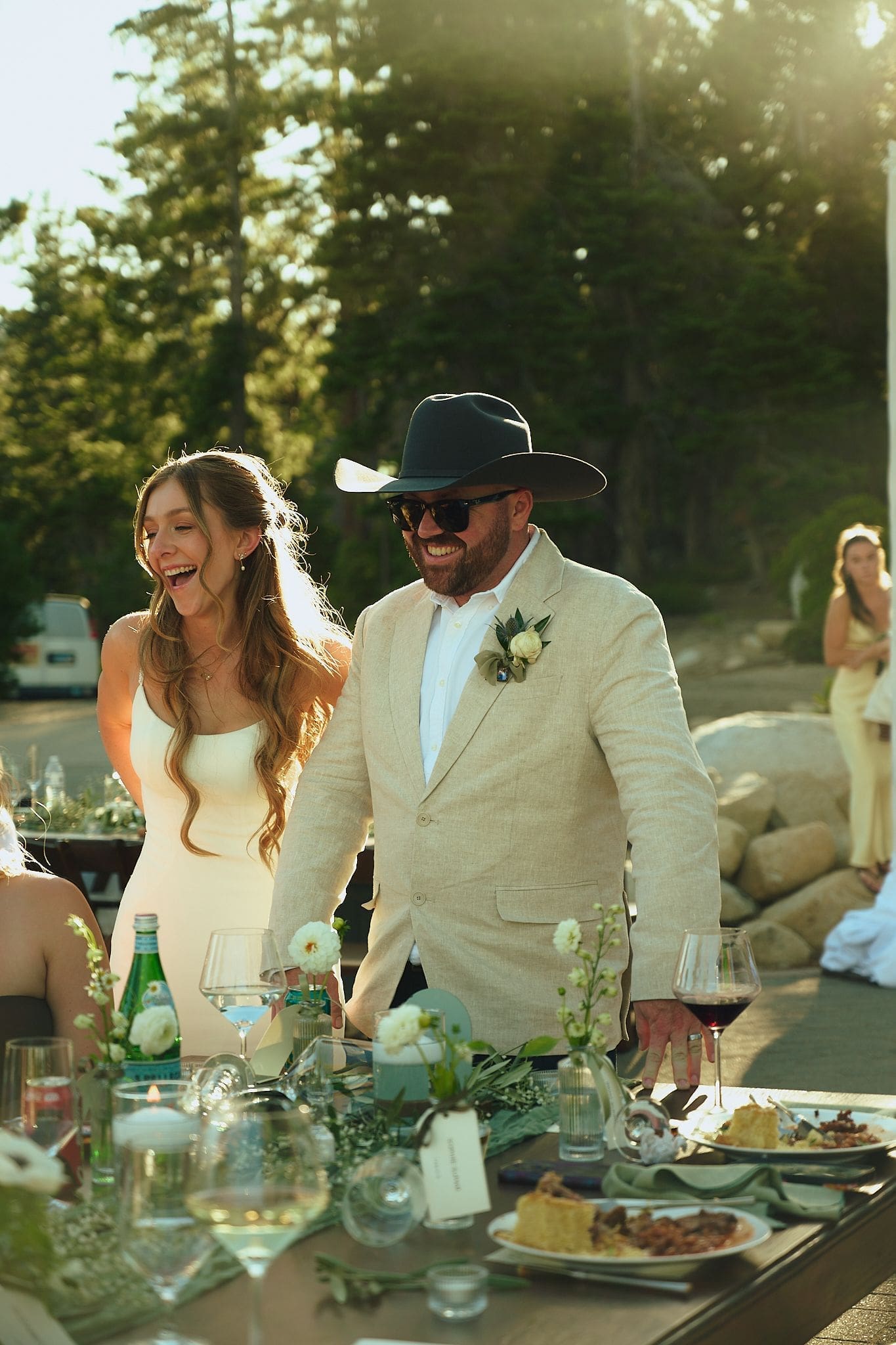 Bride and groom laughing at their outdoor Lake Tahoe wedding reception table