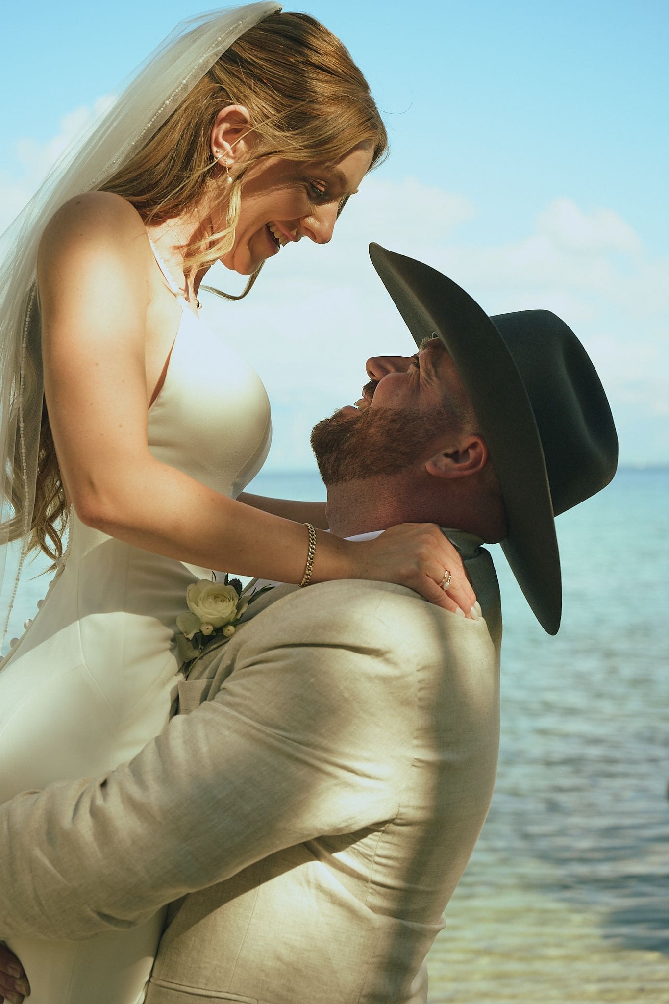 Groom lifting his bride in a joyful moment by the water at their Lake Tahoe wedding