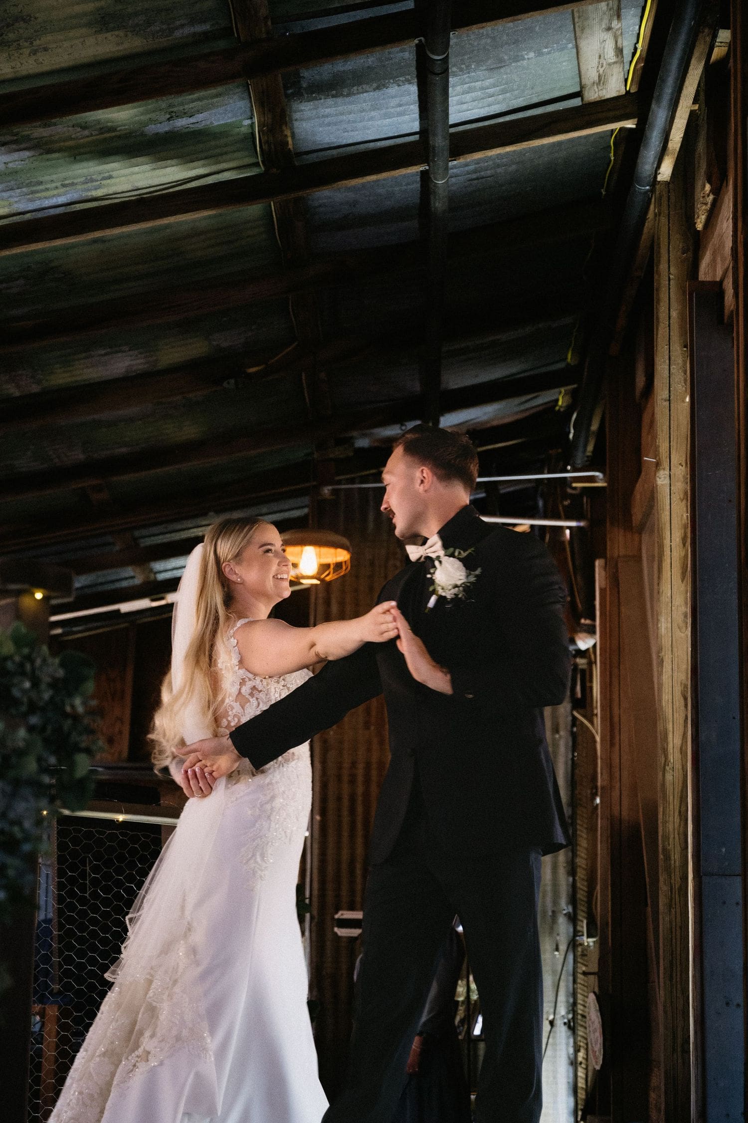 Bride and groom sharing their first dance inside a barn venue at Sovignon Ranch